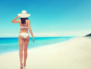 Image showing young woman in white bikini swimsuit from back