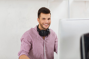 Image showing creative man with headphones and computer