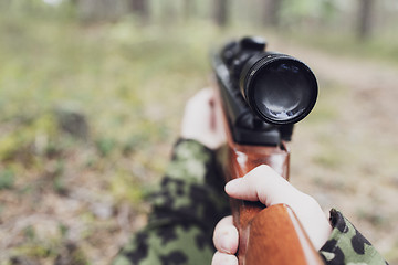 Image showing close up of soldier or hunter with gun in forest