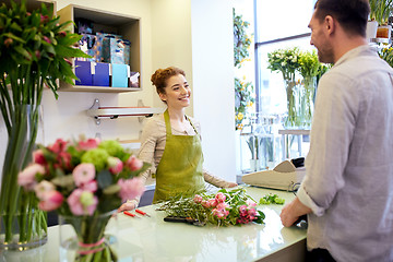 Image showing smiling florist woman and man at flower shop