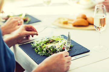 Image showing close up of woman eating salad at restaurant