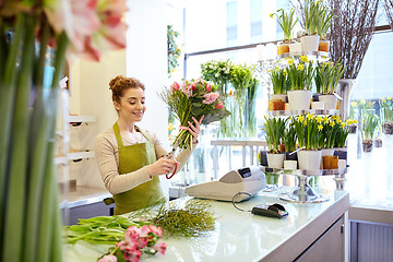 Image showing smiling florist woman making bunch at flower shop