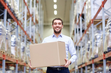 Image showing happy man with cardboard parcel box at warehouse