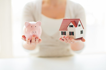 Image showing close up of woman with house model and piggy bank