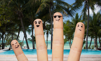 Image showing close up of fingers with smiley faces on beach