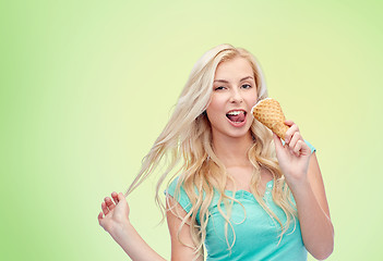 Image showing happy young woman in sunglasses eating ice cream