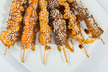 Image showing Grilled juicy skewered shashlik on a plate, sesame