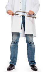 Image showing Crazy doctor is holding a big saw in his hands