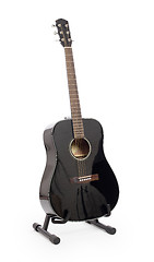 Image showing Black acoustic guitar on stand, isolated