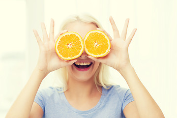 Image showing happy woman having fun covering eyes with orange