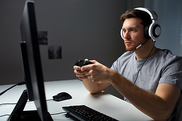 Image showing man in headset playing computer video game at home