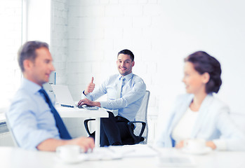 Image showing happy businessman showing thumbs up in office