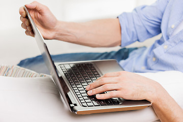 Image showing close up of man typing on laptop computer at home