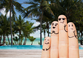 Image showing close up of fingers with smiley faces on beach