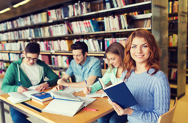 Image showing happy students reading books in library