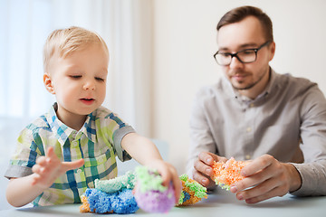 Image showing father and son playing with ball clay at home