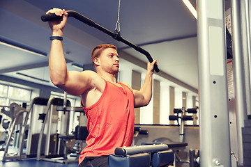 Image showing man flexing muscles on cable machine gym