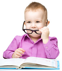 Image showing Little child play with book