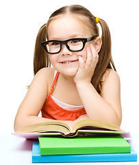 Image showing Little girl is reading a book