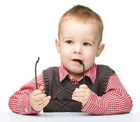 Image showing Little child is biting glasses