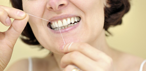 Image showing Woman flossing her teeth 