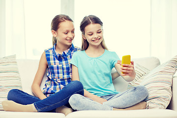 Image showing happy girls with smartphone taking selfie at home