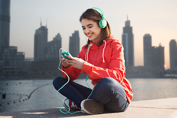 Image showing happy young woman with smartphone and headphones