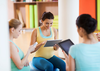 Image showing happy pregnant women with gadgets in gym