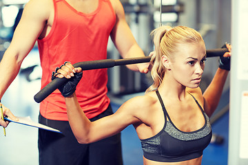 Image showing man and woman flexing muscles on gym machine