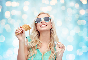 Image showing happy young woman in sunglasses eating ice cream