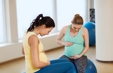 Image showing two happy pregnant women sitting on balls in gym