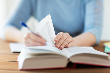 Image showing close up of student with book and notebook at home