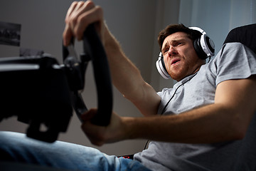 Image showing man playing car racing video game at home