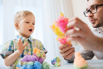 Image showing father and son playing with ball clay at home