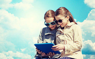 Image showing happy girls with tablet pc computer over blue sky