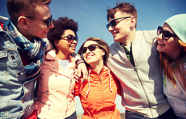 Image showing smiling friends in sunglasses laughing on street