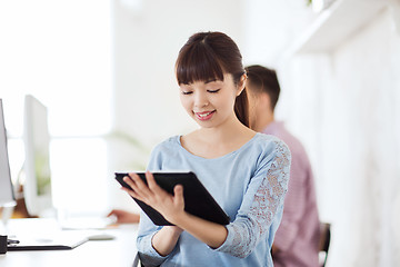 Image showing happy creative female office worker with tablet pc