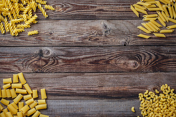 Image showing Mixed dried pasta selection on wooden background.