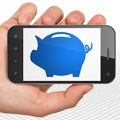 Image showing Currency concept: Hand Holding Smartphone with Money Box on display