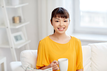 Image showing happy asian woman drinking from tea cup