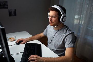 Image showing man in headset playing computer video game at home