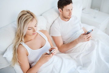 Image showing couple with smartphones in bed