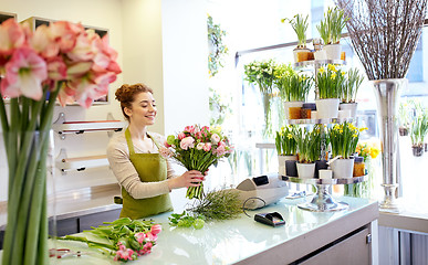 Image showing smiling florist woman making bunch at flower shop