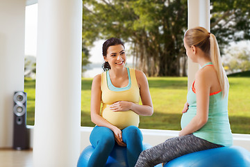 Image showing two happy pregnant women sitting on balls in gym