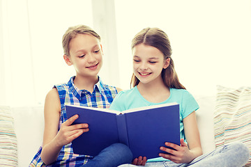Image showing two happy girls reading book at home