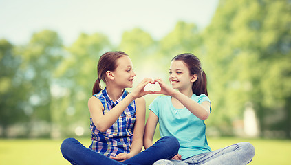 Image showing happy little girls showing heart shape hand sign