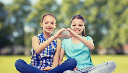 Image showing happy little girls showing heart shape hand sign