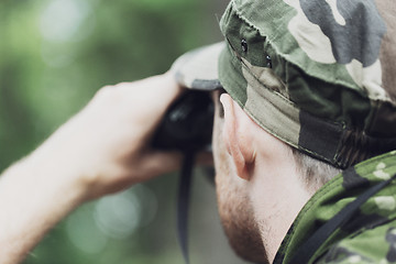 Image showing close up of soldier or hunter with binocular