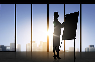 Image showing silhouette of woman with flipboard over office