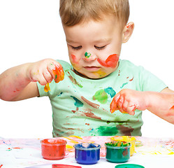 Image showing Little boy is playing with paints